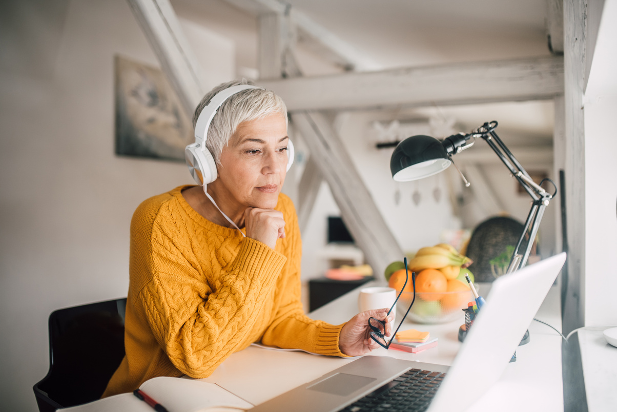 Older business woman with headphones